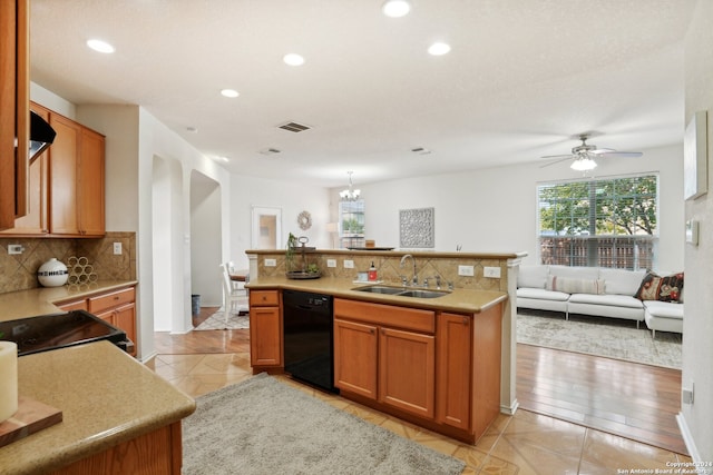 kitchen featuring decorative backsplash, kitchen peninsula, sink, black appliances, and light hardwood / wood-style flooring