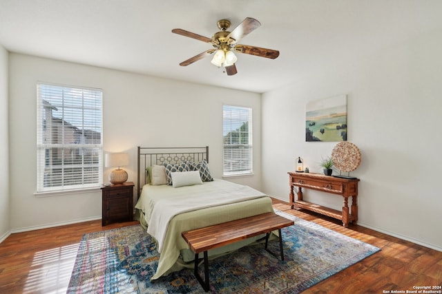 bedroom featuring ceiling fan, wood-type flooring, and multiple windows