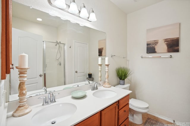 bathroom featuring vanity, toilet, and a shower with shower door