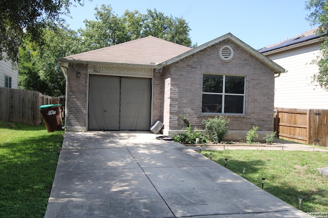 ranch-style home featuring a garage and a front lawn