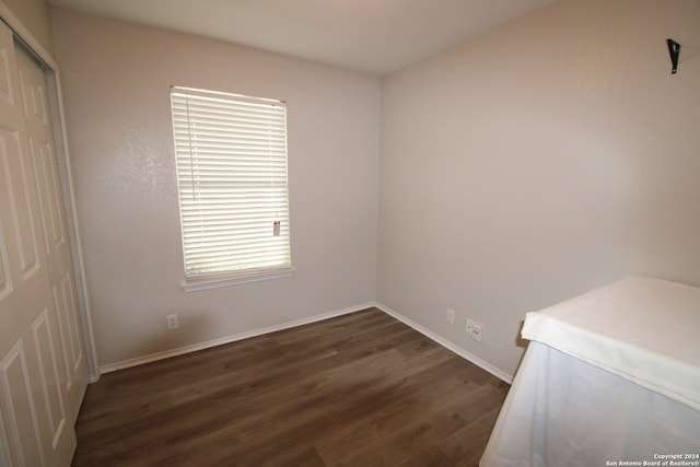 unfurnished room with dark wood-type flooring