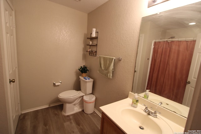 bathroom featuring hardwood / wood-style flooring, vanity, toilet, and a shower with curtain