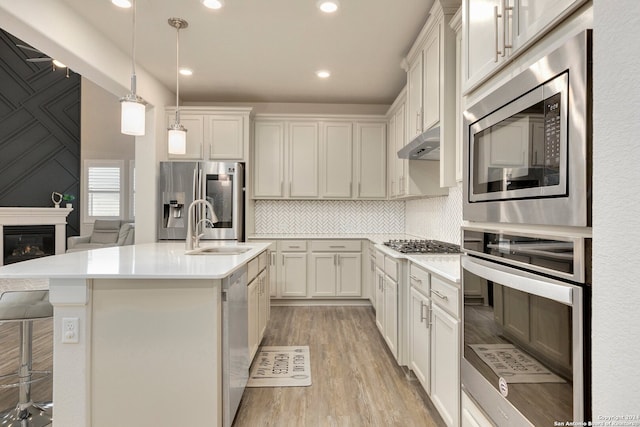 kitchen with white cabinetry, sink, a center island with sink, and appliances with stainless steel finishes