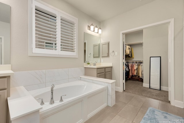 bathroom with a bathing tub, tile patterned flooring, and vanity