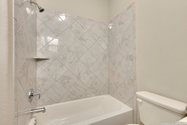 bathroom featuring tiled shower / bath combo and toilet