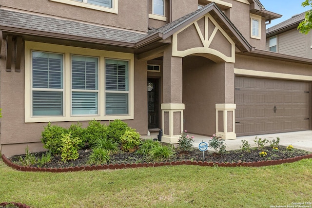 property entrance featuring a lawn and a garage