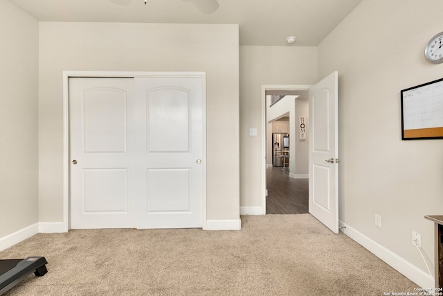 unfurnished bedroom with light carpet, a closet, and ceiling fan