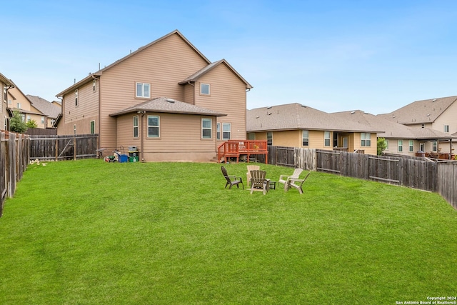 rear view of property with a yard and a deck