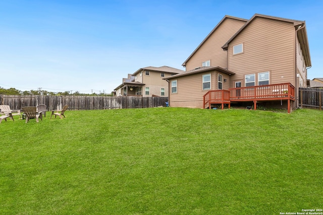 back of property with a lawn and a wooden deck