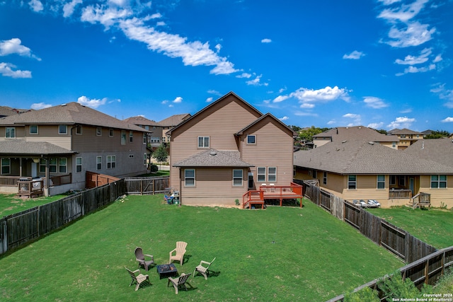 rear view of house with a lawn and a wooden deck