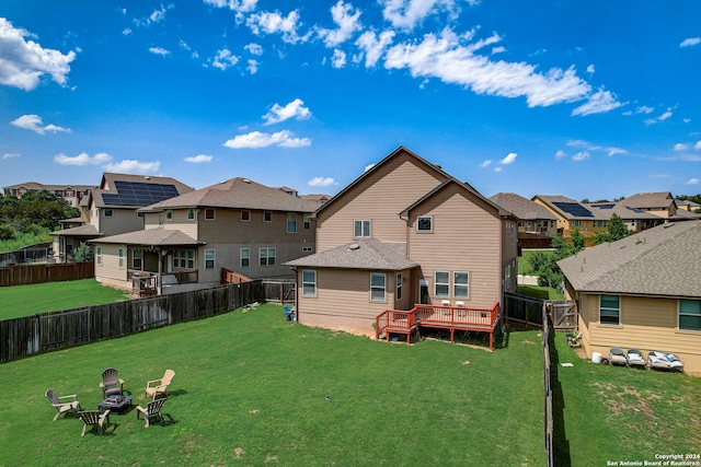 rear view of property featuring a lawn and a wooden deck