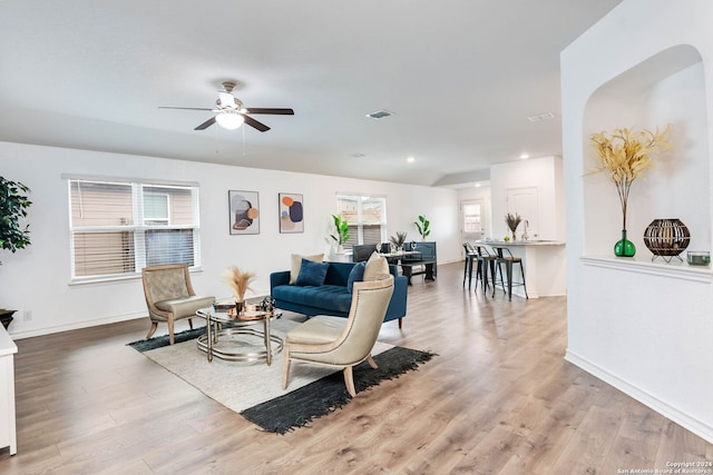 living room with light hardwood / wood-style floors and ceiling fan