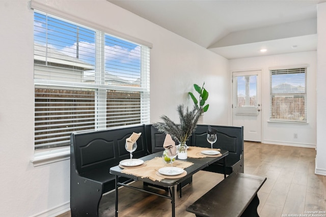 dining area with lofted ceiling and light wood-type flooring