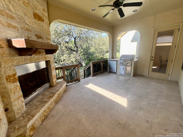 view of patio with a grill, ceiling fan, and an outdoor kitchen