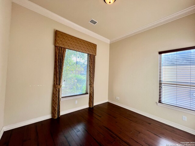 spare room with dark hardwood / wood-style flooring and ornamental molding