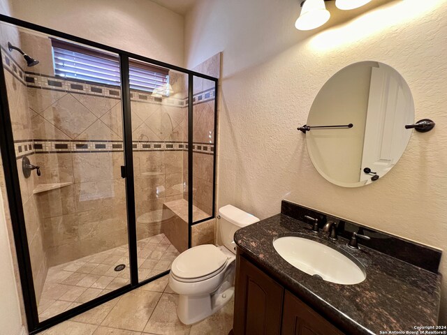 bathroom with tile patterned floors, walk in shower, vanity, and toilet