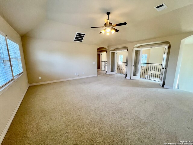 unfurnished room featuring ceiling fan, light colored carpet, and vaulted ceiling