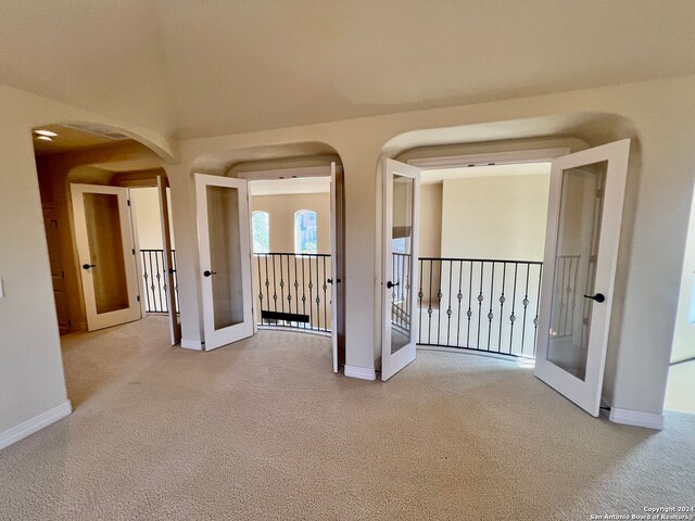 carpeted spare room featuring french doors