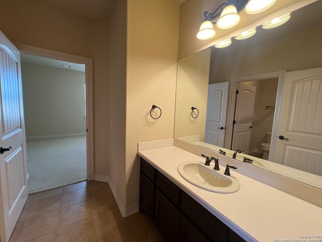 bathroom featuring tile patterned flooring, vanity, and toilet