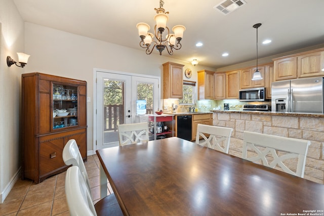 dining area featuring french doors, sink, and a chandelier