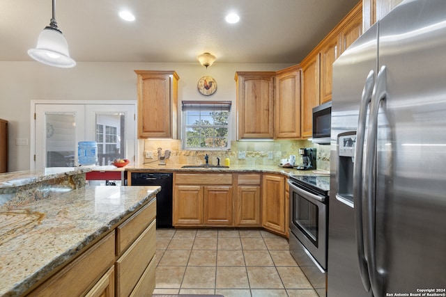 kitchen featuring decorative backsplash, appliances with stainless steel finishes, light stone countertops, sink, and pendant lighting