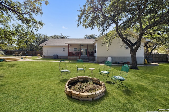 back of property with central air condition unit, ceiling fan, and a yard