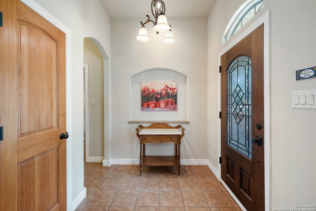 foyer featuring a chandelier and light tile patterned flooring