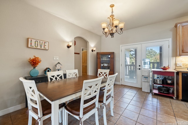 tiled dining space featuring french doors and a notable chandelier