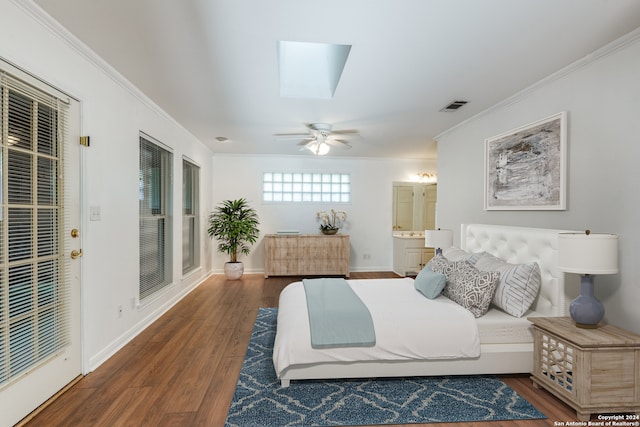 bedroom featuring a skylight, ceiling fan, dark wood-type flooring, and ornamental molding