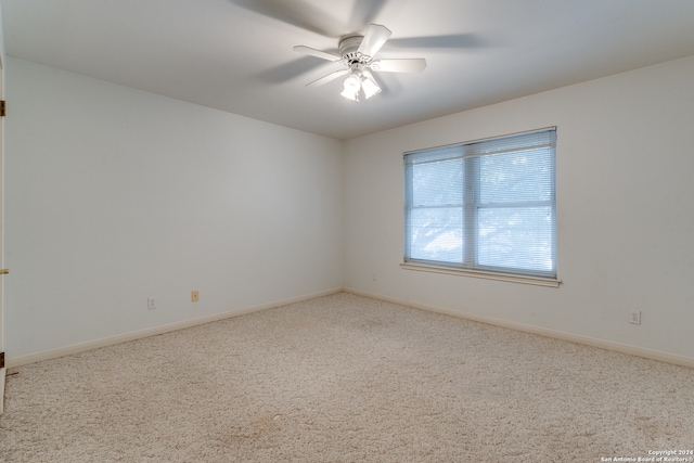 spare room featuring ceiling fan and carpet