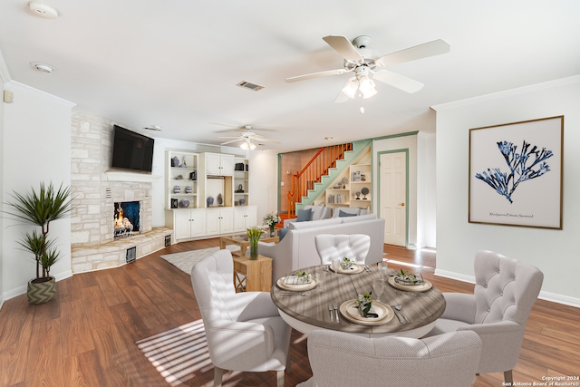 dining space with crown molding, a fireplace, and wood-type flooring