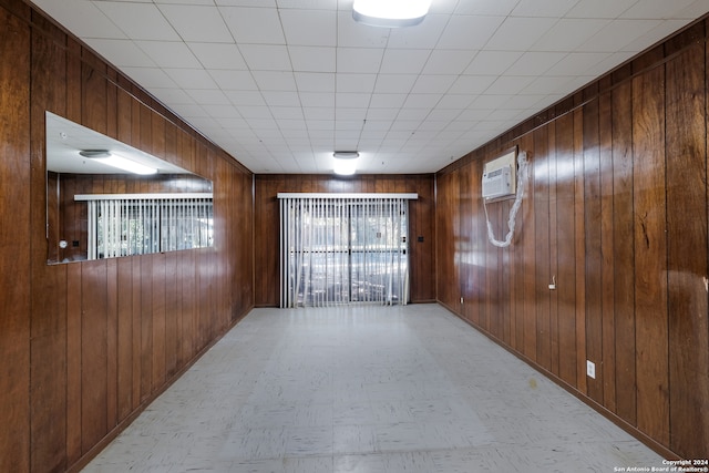 empty room featuring a wall unit AC and wood walls