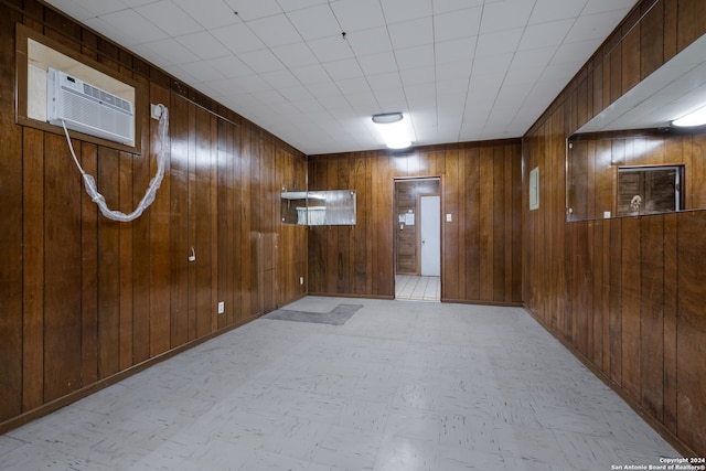 empty room with an AC wall unit and wood walls