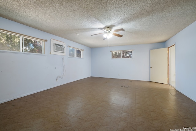 empty room featuring plenty of natural light, ceiling fan, and a textured ceiling