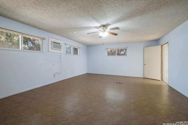 3947 Gayle Ave, San Antonio, TX 78223 - spare room with ceiling fan, a wall mounted AC, a textured ceiling, and baseboards
