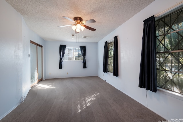 spare room with carpet, a textured ceiling, and ceiling fan