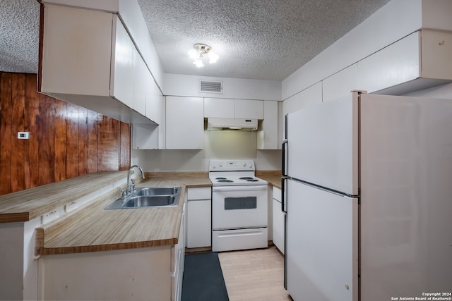 kitchen featuring white appliances, sink, light wood-type flooring, a textured ceiling, and white cabinetry