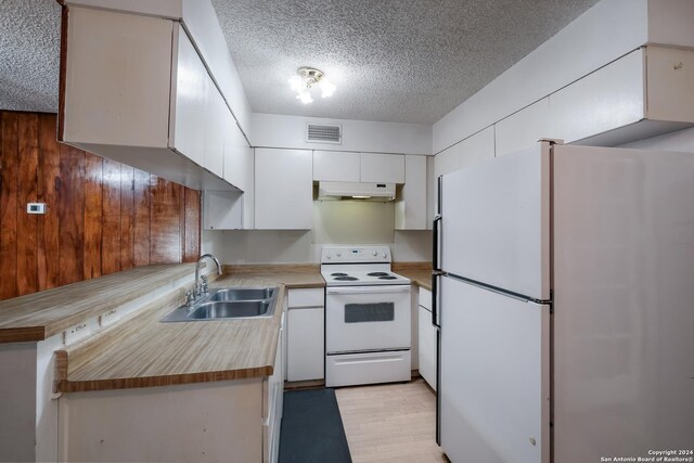 3947 Gayle Ave, San Antonio, TX 78223 - kitchen featuring white appliances, under cabinet range hood, a sink, a textured ceiling, and white cabinets