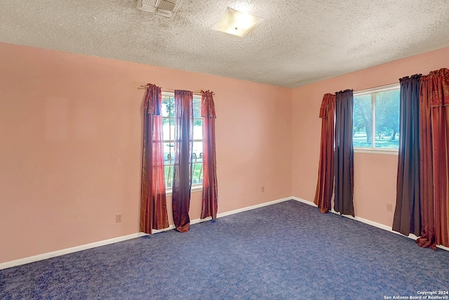 5010 David Scott, Kirby, TX 78219 - empty room featuring healthy amount of natural light, dark colored carpet, a textured ceiling, and baseboards