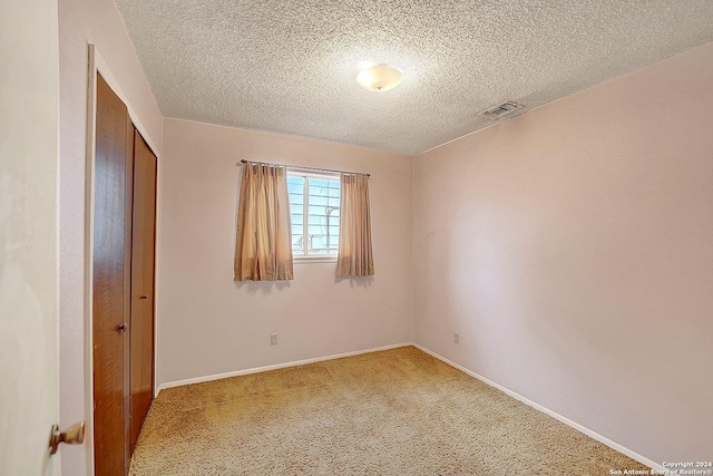 5010 David Scott, Kirby, TX 78219 - unfurnished bedroom with light colored carpet, a textured ceiling, a closet, and baseboards