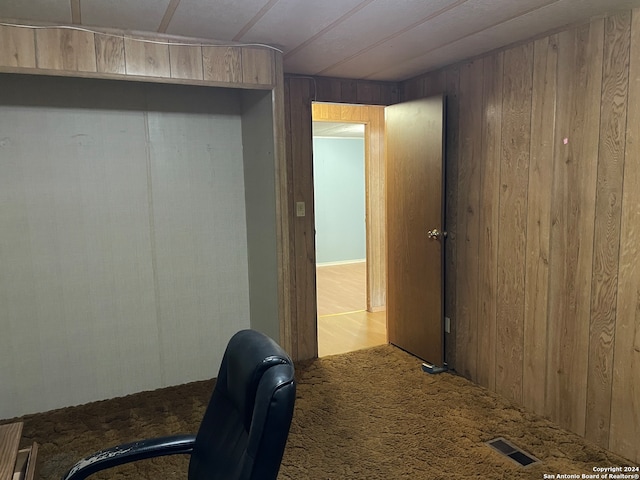 carpeted office space with wooden walls