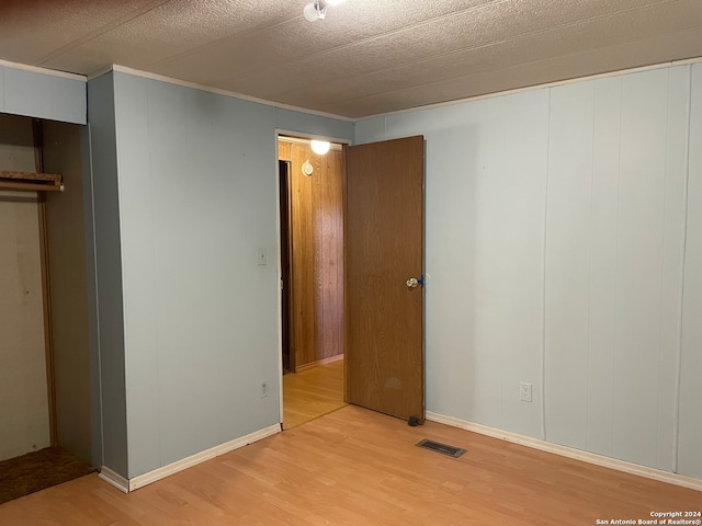 unfurnished bedroom with hardwood / wood-style flooring and a textured ceiling