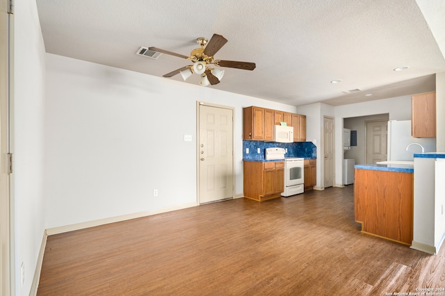 kitchen featuring a textured ceiling, tasteful backsplash, dark hardwood / wood-style floors, and white appliances