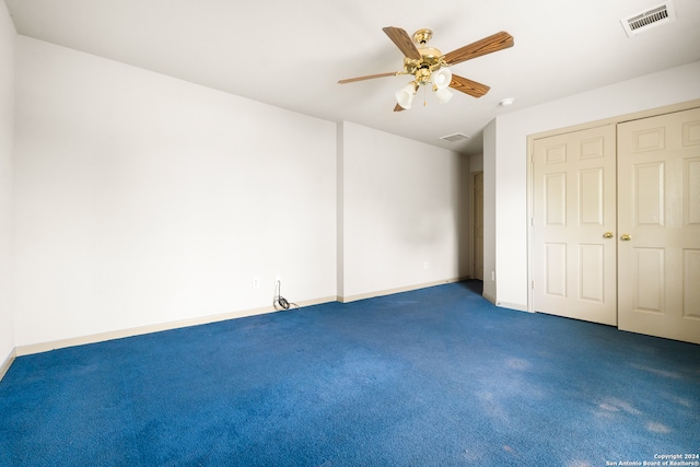 unfurnished bedroom featuring ceiling fan, dark carpet, and a closet