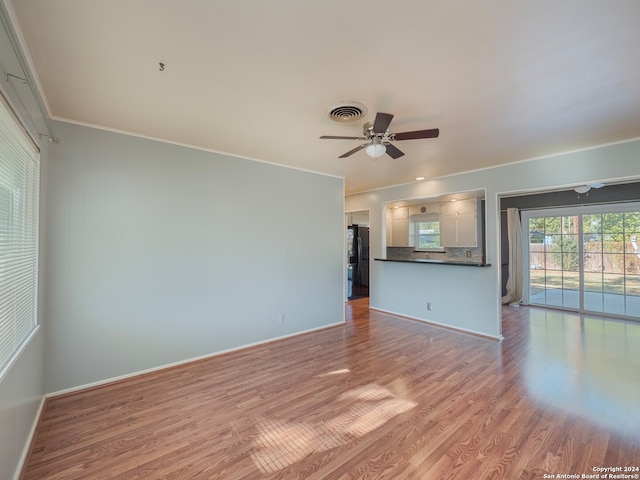 unfurnished living room with ceiling fan, light hardwood / wood-style floors, and ornamental molding