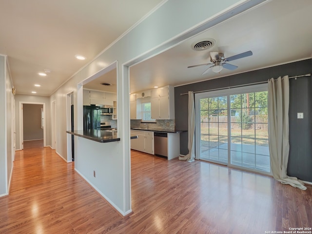 kitchen with decorative backsplash, stainless steel appliances, ceiling fan, light hardwood / wood-style flooring, and white cabinetry