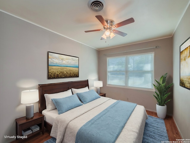 bedroom featuring dark hardwood / wood-style floors, ceiling fan, and ornamental molding