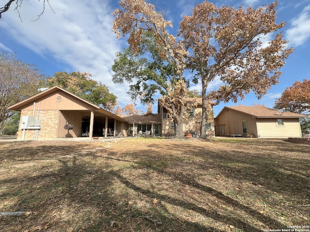 rear view of property featuring a lawn