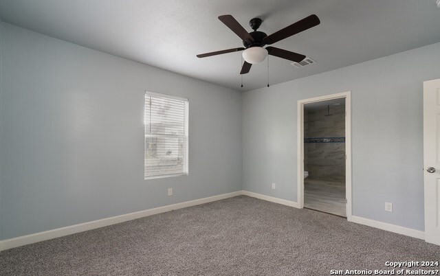 unfurnished bedroom with carpet flooring, ceiling fan, and a spacious closet