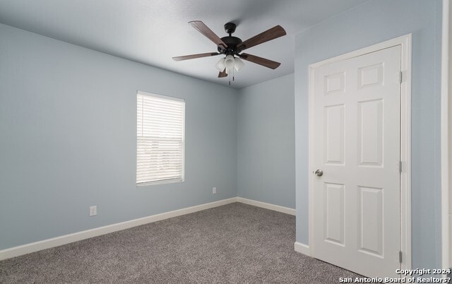 spare room featuring light carpet and ceiling fan